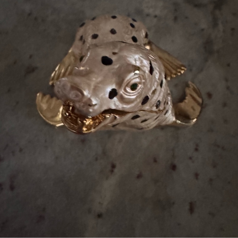cream walrus with a black dot, gold trim, and green crystal eyes trinket
